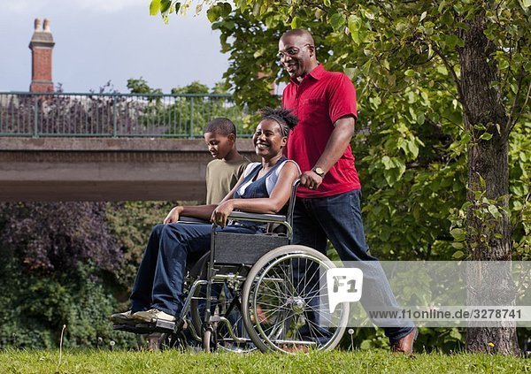 Frau im Rollstuhl mit Familie