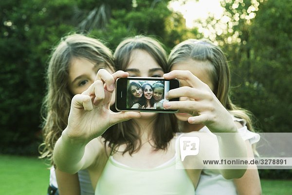 Girls taking photo with mobile phone