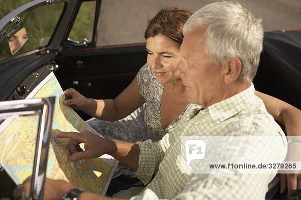 Seniorenpaar mit Auto und Karte