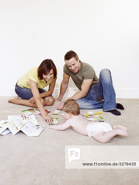 Junge Familie auf dem Boden mit Farbmustern