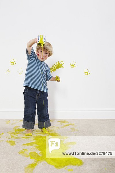 Kleinkind Junge gießt Farbe auf den Teppich