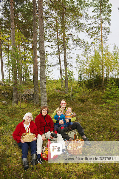 Family with mushroom baskets in forest