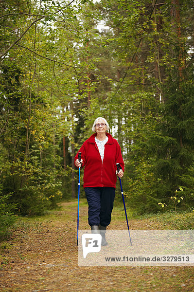 Ältere Frau beim Wandern im Wald