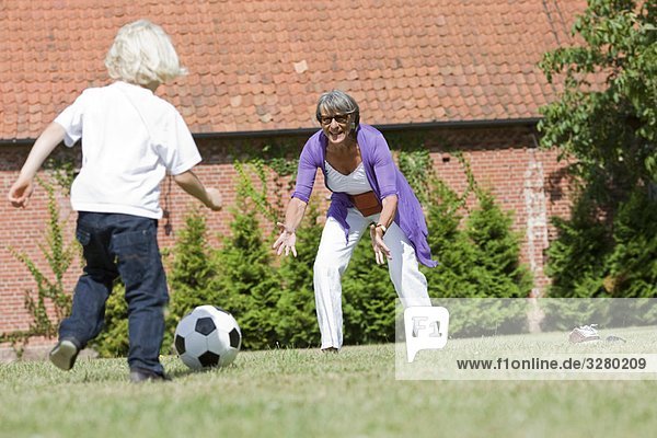 Großmutter und Kind beim Fußballspielen