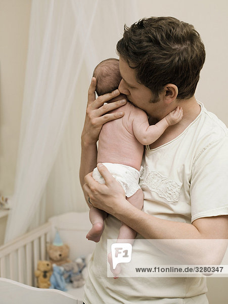 Ein Vater hält sein neugeborenes Baby.