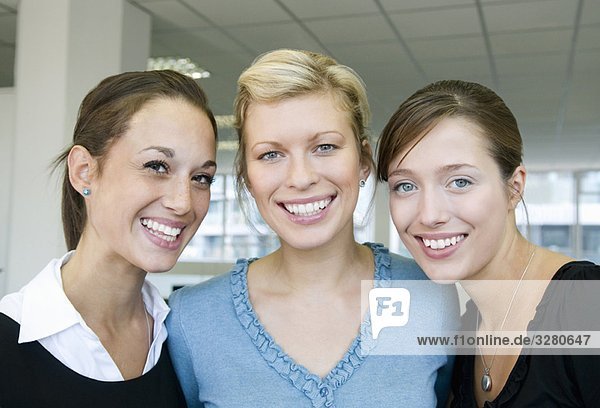 Drei Geschäftskolleginnen lächeln
