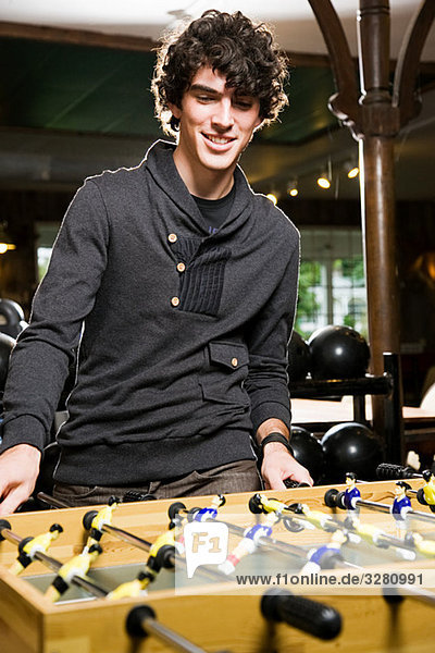 Young man playing table football