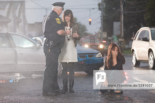Police officer and young women at scene of accident