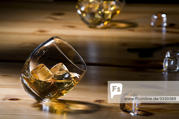 Whiskygläser und Eiswürfel auf einem Holztisch