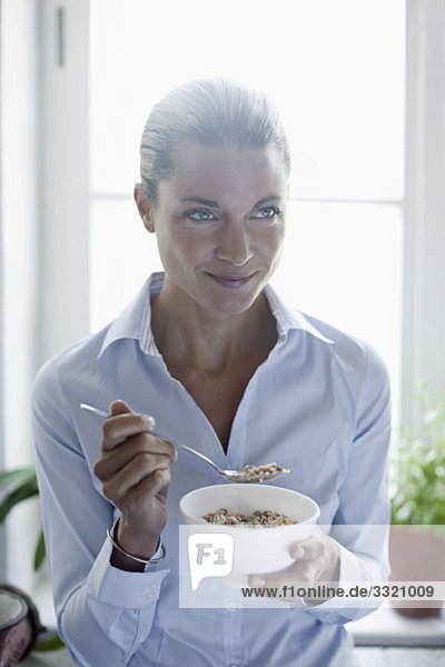 A woman eating a bowl of cereal