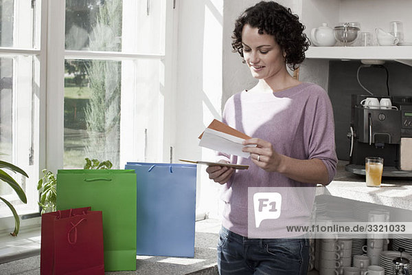 A woman standing next to gift bags and looking at cards