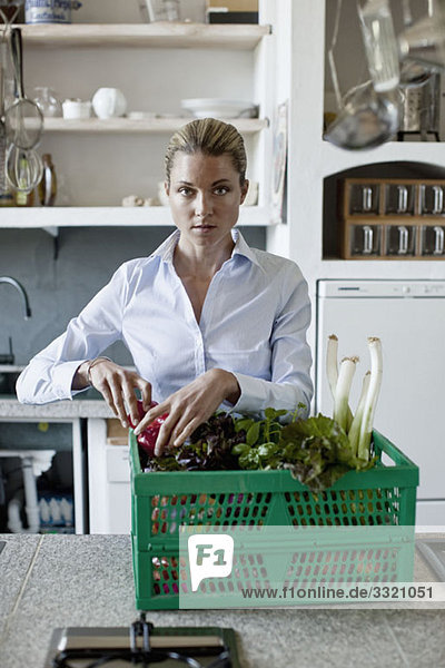 Eine Frau in der Küche mit einem Gemüsekorb