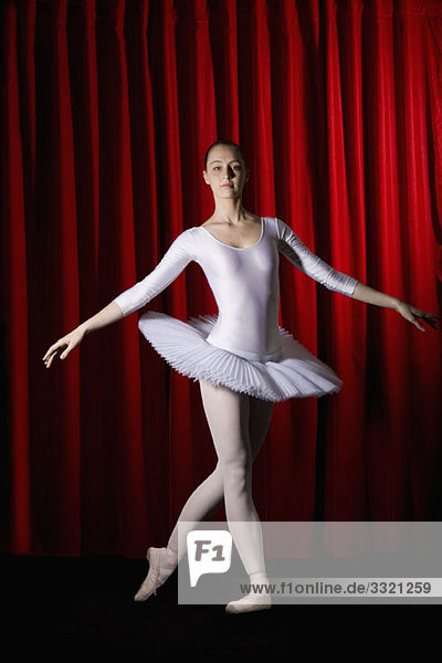 Eine Balletttänzerin  die auf der Bühne posiert.