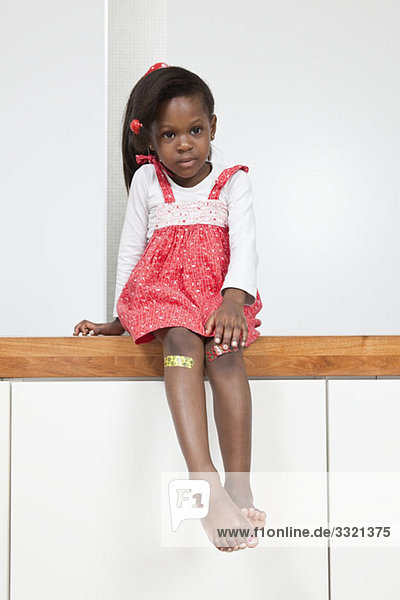 A young girl with a bandage on each knee
