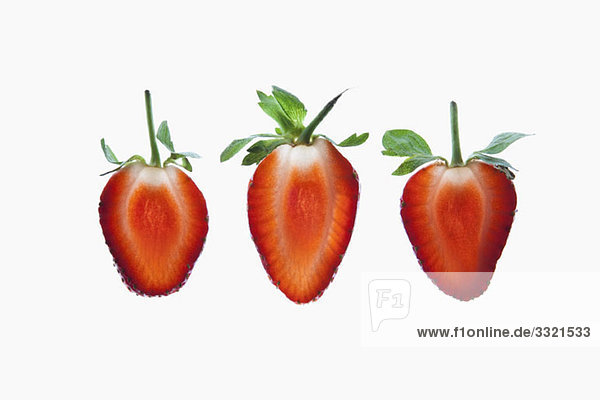 Drei Scheiben einer Bio-Erdbeere auf einem Leuchtkasten