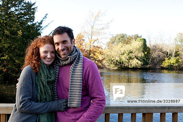 Porträt eines glücklichen Paares auf einer Flussbrücke