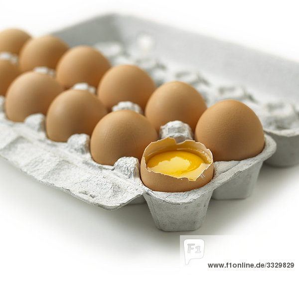 Gebrochen braun Ei in einem Karton auf weißem Hintergrund