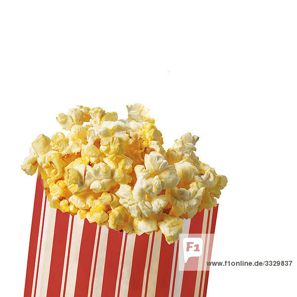 Popcorn in einem gestreiften Beutel auf weißem Hintergrund