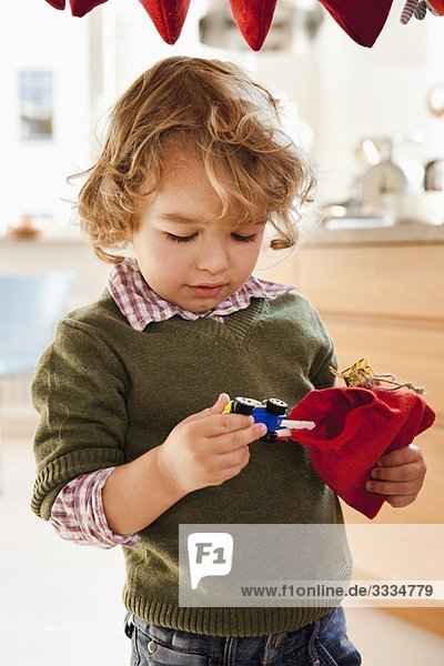 Junge zieht Spielzeug aus dem Geschenksack