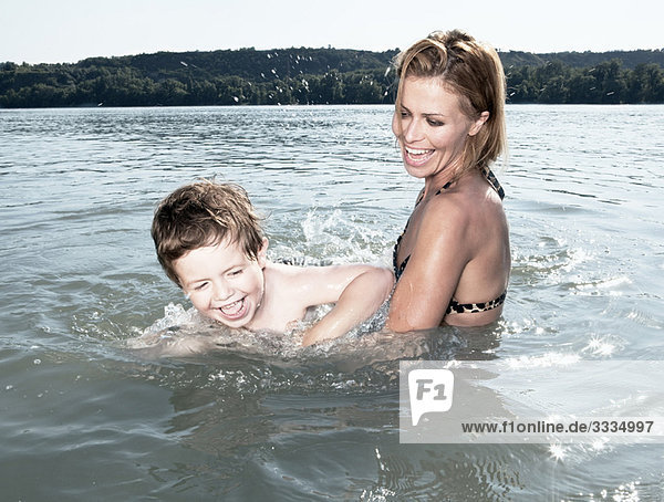 Mutter bringt dem Kind das Schwimmen bei