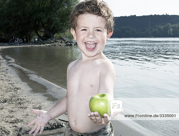 Kind hält Apfel am Fluss