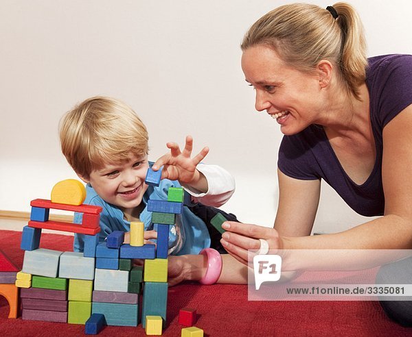 Mutter und Sohn spielen mit Bausteinen