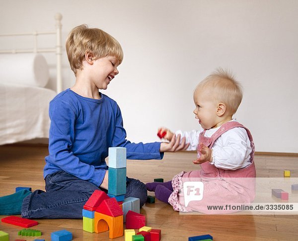 Junge und Baby mit Spielzeugbausteinen