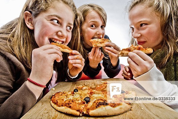 3 teenagers eating pizza