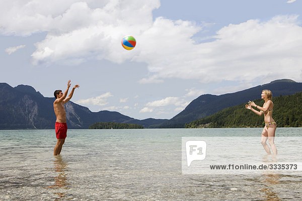 A young couple playing with a beach ball