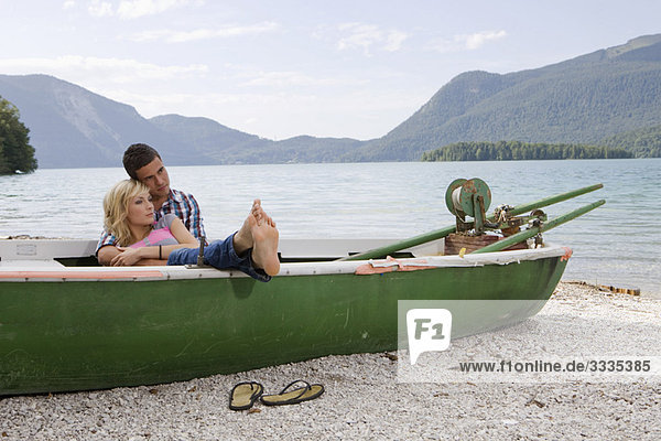 Ein junges Paar träumt in einem Boot.