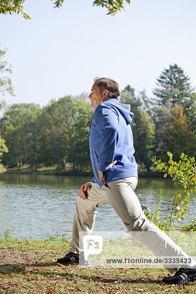 Man stretching beside lake
