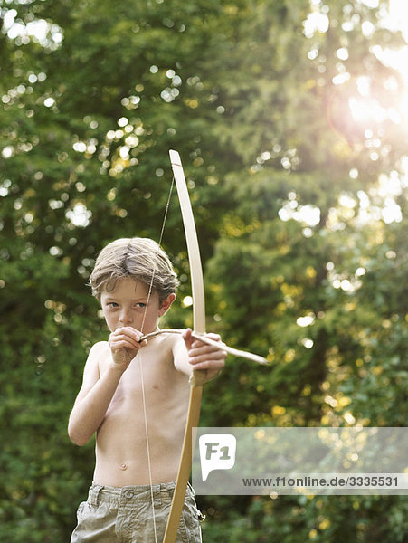 Young boy plays with bow and arrow