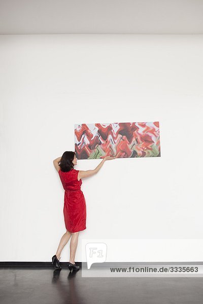 woman hanging up a picture