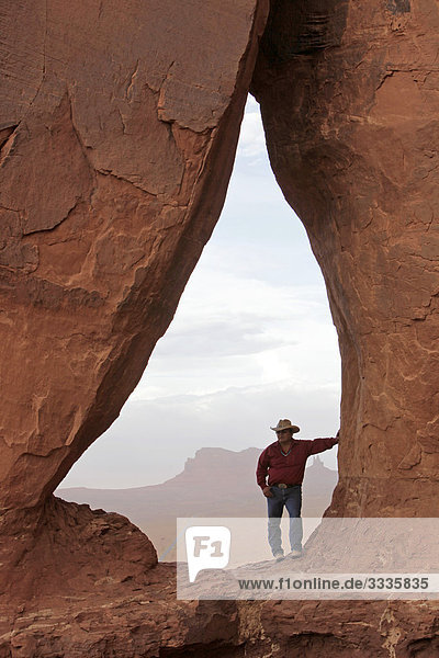 Mann in einem Loch im Felsen stehend  Monument Valley  Arizona  USA