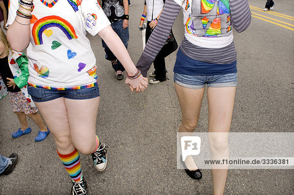 Two gay women holding hands  marching in gay rights parade  Durham  North Carolina