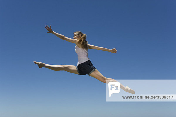 Junge Frau springt,  mitten in der Luft