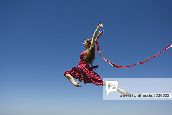 Junge Frau springt  mitten in der Luft