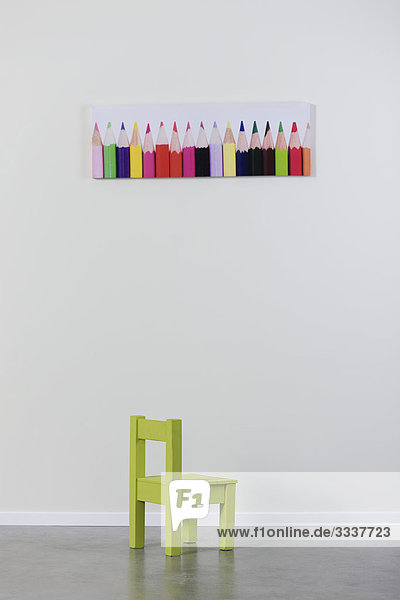 Leerer Stuhl unter dem Bild von Buntstiften Leerer Stuhl unter dem Bild von Buntstiften
