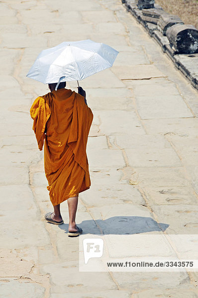 Buddhistischer Mönch mit Sonnenschirm  Angkor  Kambodscha  Rückansicht