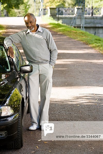Senior man standing by a black car  Sweden.