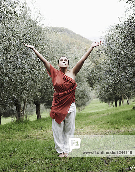 Frau durchführen Yoga in einem Olivenhain  Italien.