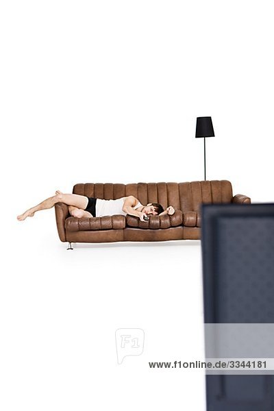 liegend liegen liegt liegendes liegender liegende daliegen Mann sehen Fernsehen jung Couch