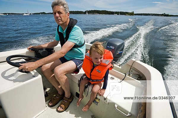 Grandfather and grandson in a boat  Stockholm archipelago  Sweden.