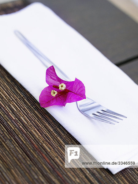 Gabel-auf einer weißen Serviette dekoriert mit einer purpurroten Blume  Südafrika.