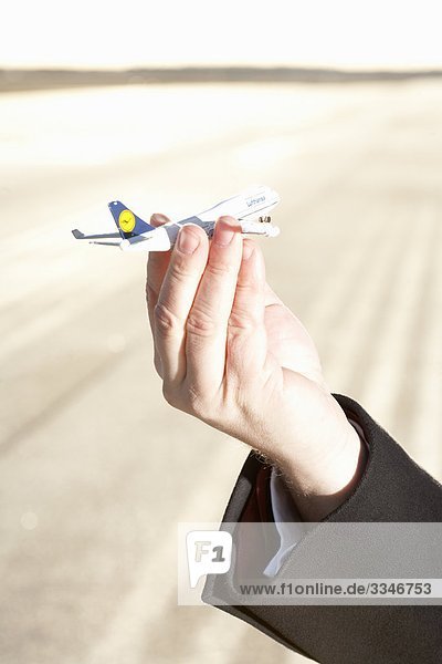 Eine Hand hält eine Miniatur-Flugzeug Schweden.
