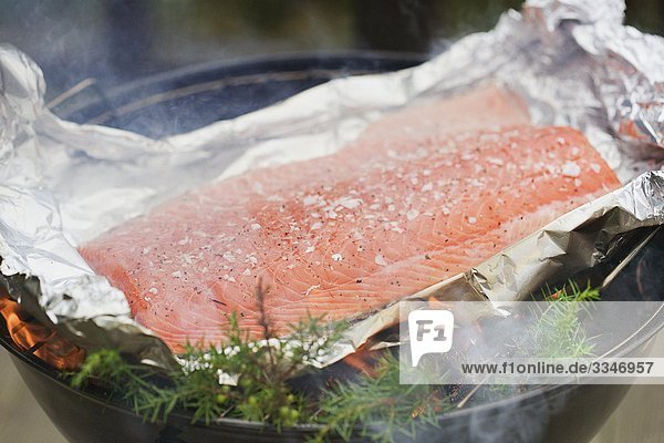 Salmon in foil on a grill,  Sweden.