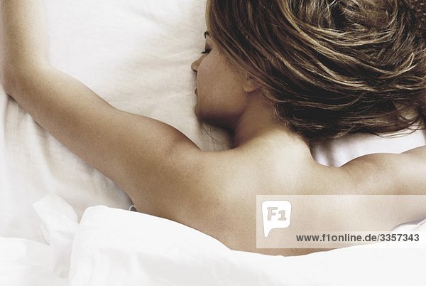 Junge Frau im Bett liegend schlafend