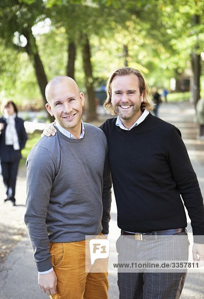 Two happy men standing outside