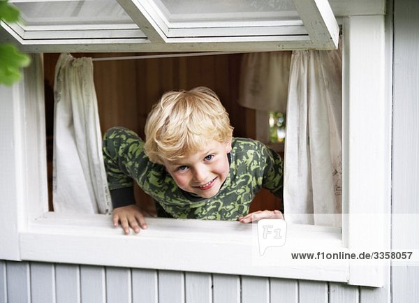 Junge spielt im Fenster