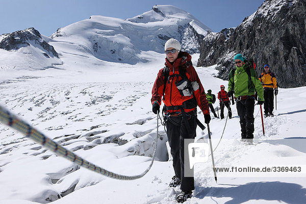 10870384  Winter  mountaineering  group  rope  glacier  ice  moraine  mountain  mountains  walking  hiking  canton Valais  Hohlaubgletscher  Allalinhorn  Alps  near Saas Fee  Switzerland  persons